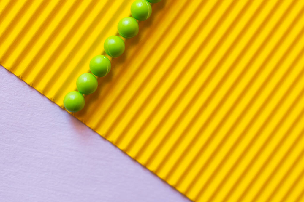 вид зверху на зелені кульки на текстурованому жовтому і фіолетовому фоні
 - Фото, зображення