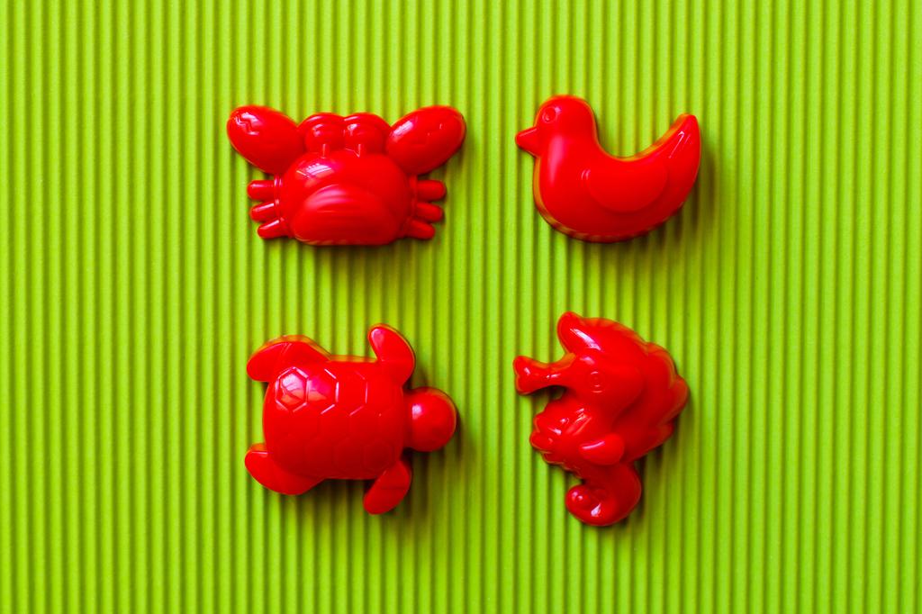 vista superior de animais marinhos vermelhos e brinquedos de pato em fundo ondulado verde - Foto, Imagem