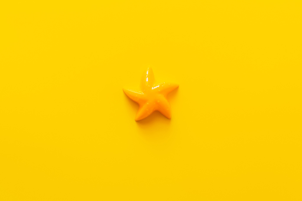 vista superior del molde de estrellas de mar de plástico sobre fondo amarillo brillante - Foto, imagen