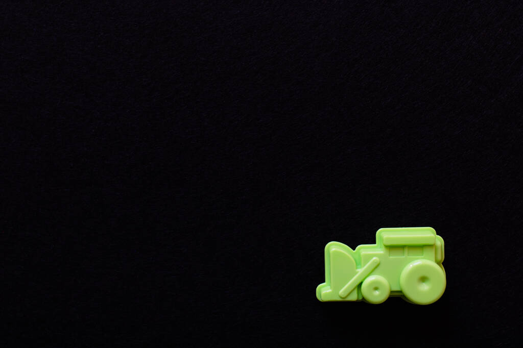 top view of green toy excavator isolated on black with copy space - Photo, Image
