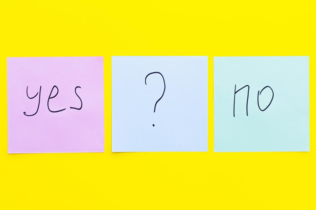 Parlak sarı arkaplanda evet ile hayır arasında soru işareti olan yapışkan notların üst görünümü - Fotoğraf, Görsel