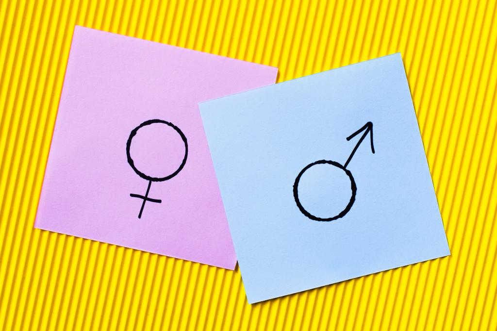вид фиолетовых карточек с символами гендерной идентичности на желтом текстурированном фоне - Фото, изображение