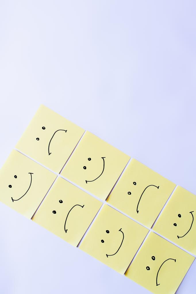 ylhäältä näkymä vaaleankeltainen tahmea muistiinpanoja onnellinen ja järkyttynyt emoji valkoisella taustalla - Valokuva, kuva