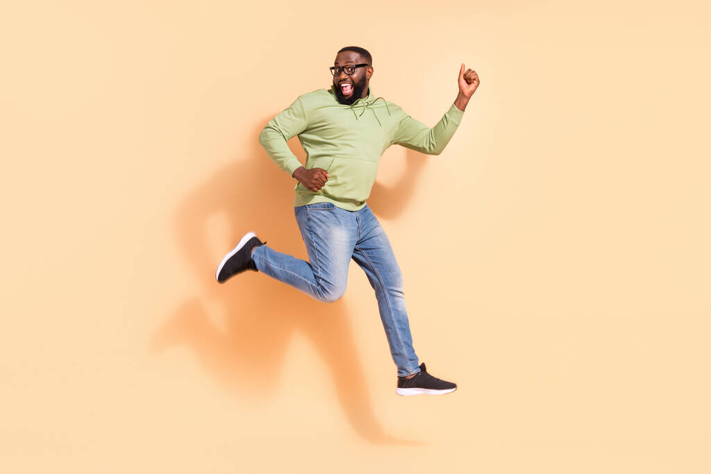 Täyspitkä kuva energinen aktiivinen mies hyppääminen hauskaa juhlia onnea eristetty beige väri tausta. - Valokuva, kuva