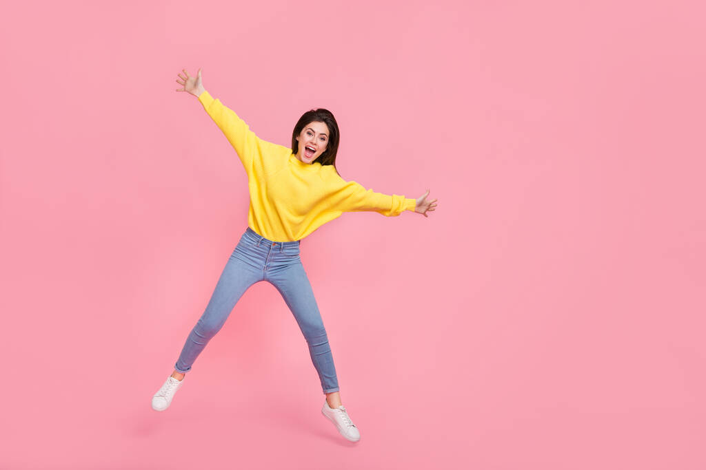 Foto corpo pieno di giovane donna allegra divertirsi jumper fly indossare abbigliamento casual isolato su sfondo di colore rosa. - Foto, immagini
