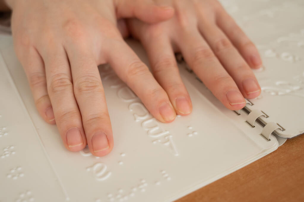Bir kadın körler alfabesini şifre çözücü kullanarak öğreniyor. - Fotoğraf, Görsel