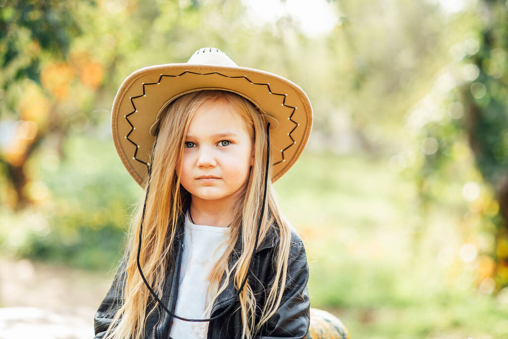 portrait of girl in cowboy hat in autumn park. Children and Ecology. Healthy nutrition Garden Food. - Photo, Image