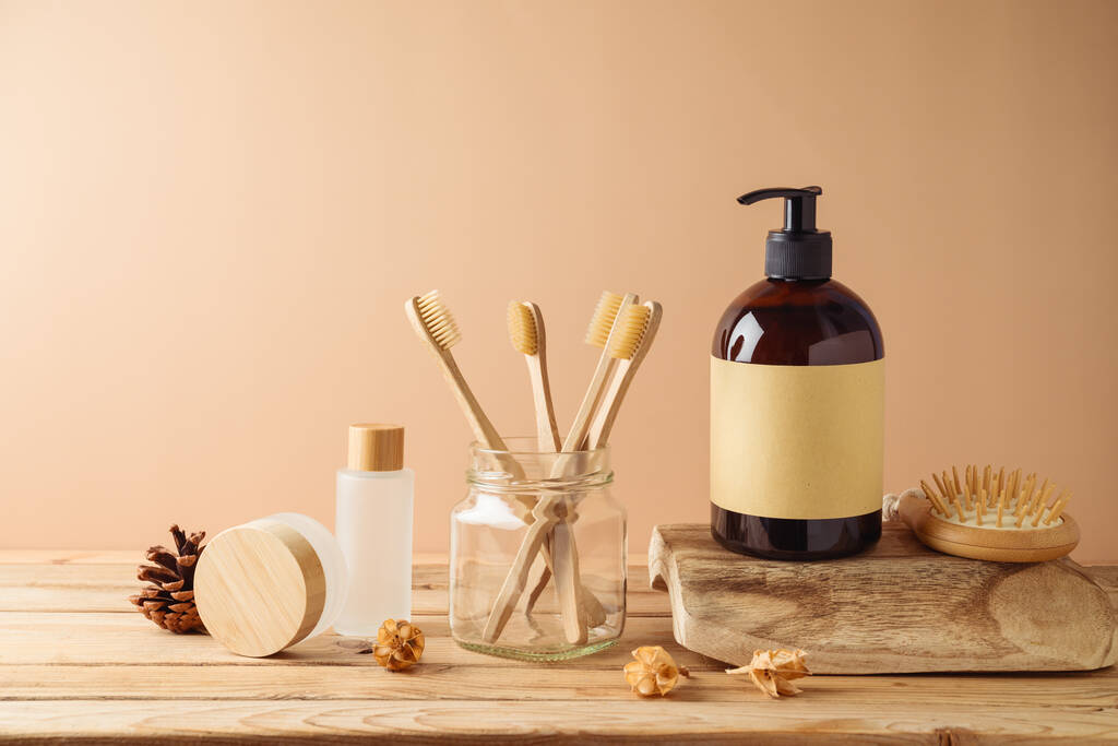 Bottiglie di cosmetici biologici naturali e spazzolino da denti ecologico per modellare il design dell'imballaggio su tavolo in legno su sfondo beige - Foto, immagini