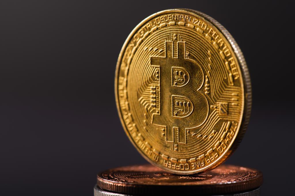 QUIIV, UCRÂNIA - 26 de abril de 2022: Vista de perto da bitcoin dourada em moedas criptografadas isoladas em preto  - Foto, Imagem