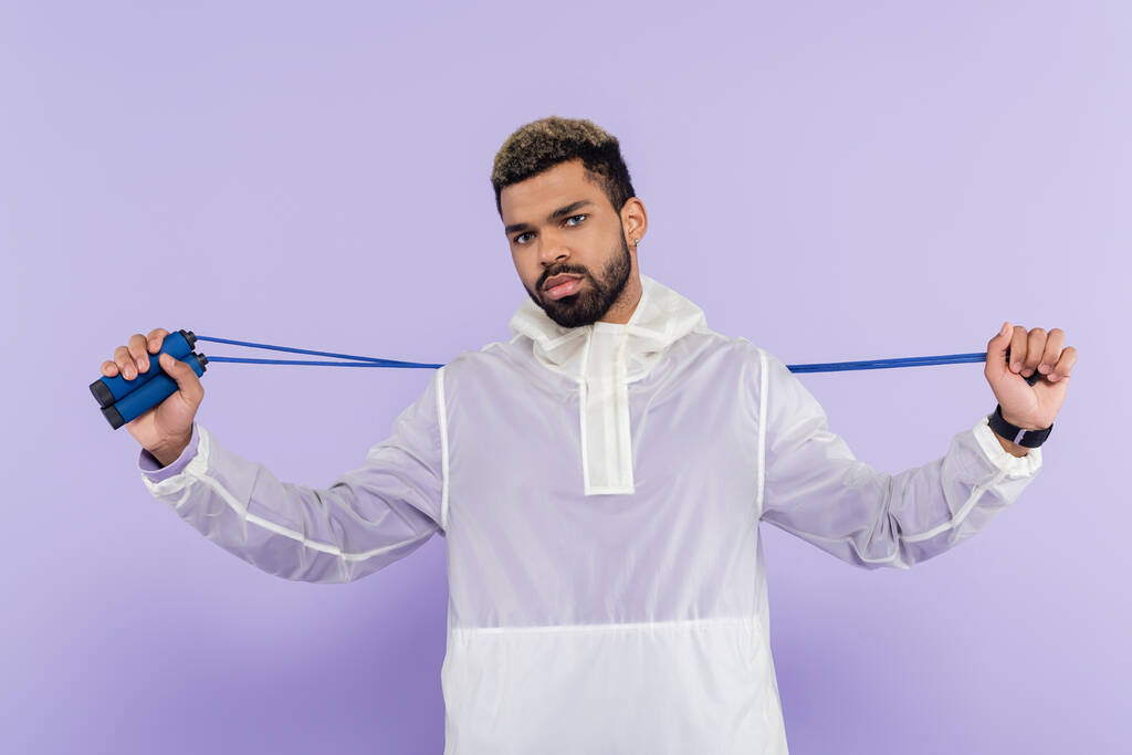бородатий афроамериканський спортсмен тримає пропускаючу мотузку ізольовано на фіолетовому
 - Фото, зображення