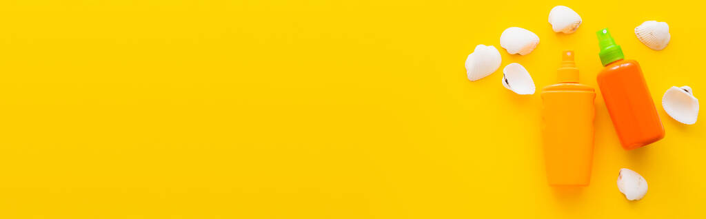 Top näkymä simpukoiden lähellä aurinkovoiteet keltaisella pohjalla, banneri  - Valokuva, kuva
