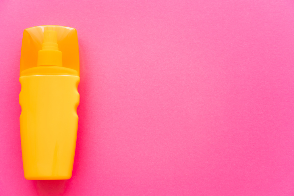 Vista superior da garrafa laranja de protetor solar na superfície rosa - Foto, Imagem