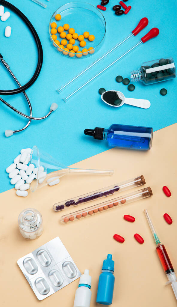Diverse medische apparatuur, ampullen, pipet, medicijnen, tabletten, capsules, spray op blauwe achtergrond. Bovenaanzicht. - Foto, afbeelding