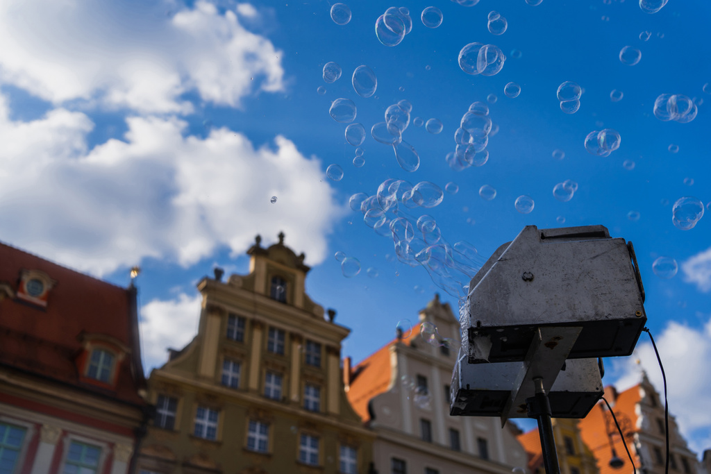 Low angle view of soap bubbles appliance on blurred urban street in Wroclaw - Photo, Image