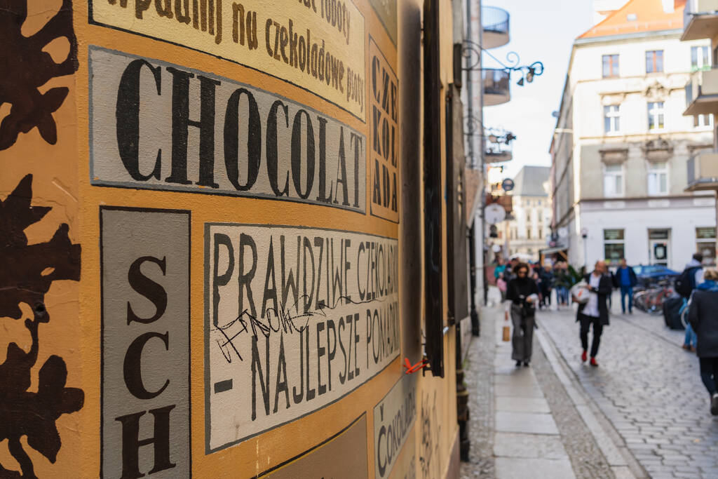 WROCLAW, POLONIA - 18 DE ABRIL DE 2022: Letras publicitarias en fachada de edificio en calle urbana  - Foto, imagen
