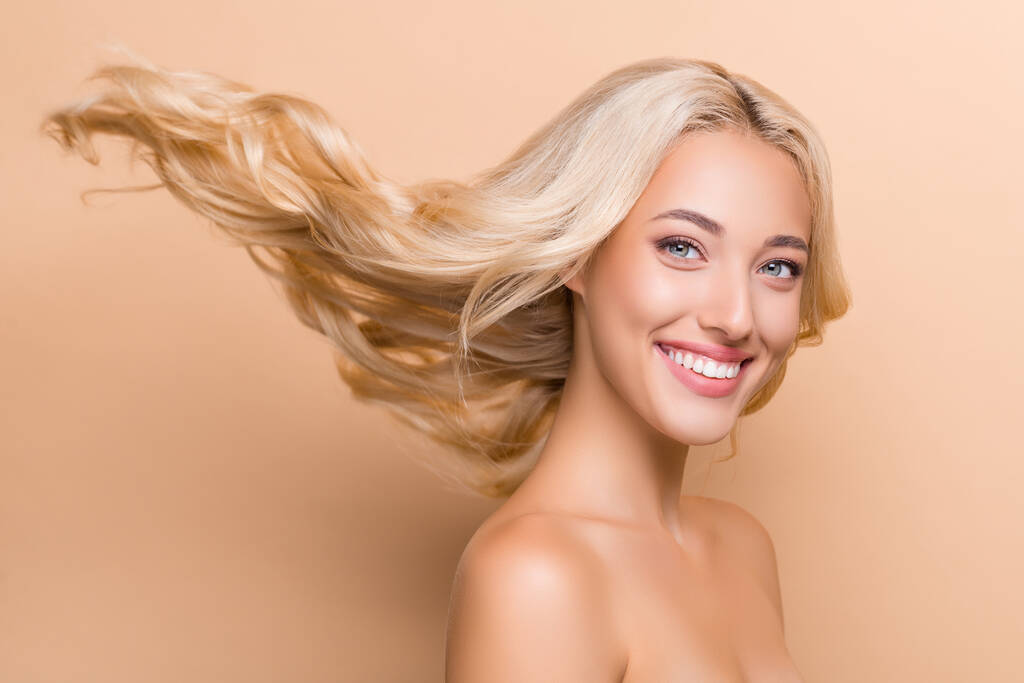 Profilo foto laterale di sorprendente signora sorridente con lunghi capelli volanti pubblicità prodotto per la cura dei capelli isolato su sfondo di colore beige. - Foto, immagini