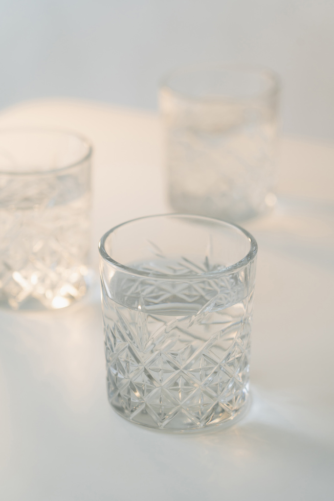 vue rapprochée du verre de cristal avec de l'eau douce sur fond gris flou  - Photo, image