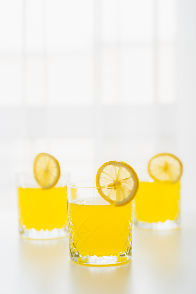 vasos con refrescante tónico cítrico y rodajas de limón sobre fondo blanco con espacio para copiar - Foto, Imagen