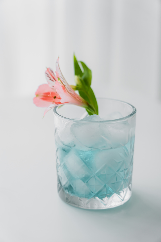 verre cristal avec fleur d'alstroemeria rose et boisson tonique glacée sur fond blanc - Photo, image