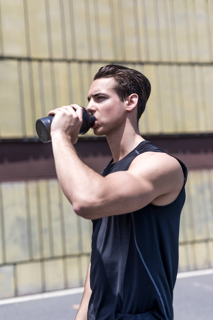 М'язистий молодий чоловік п'є воду після тренування
 - Фото, зображення