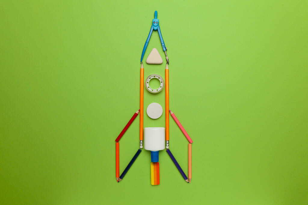 Космічний корабель (ракета) з канцтоварів на зеленому тлі. Дитяча уява, наука в початковій школі. (дошкільний
) - Фото, зображення