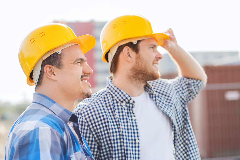 grupo de construtores sorridentes em hardhats ao ar livre
 - Foto, Imagem