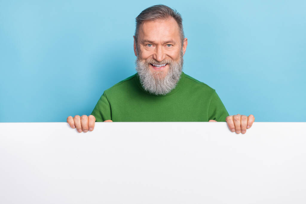 Photo of middle aged man stand over white space wall discount offer present ads isolated blue color background. - Photo, Image