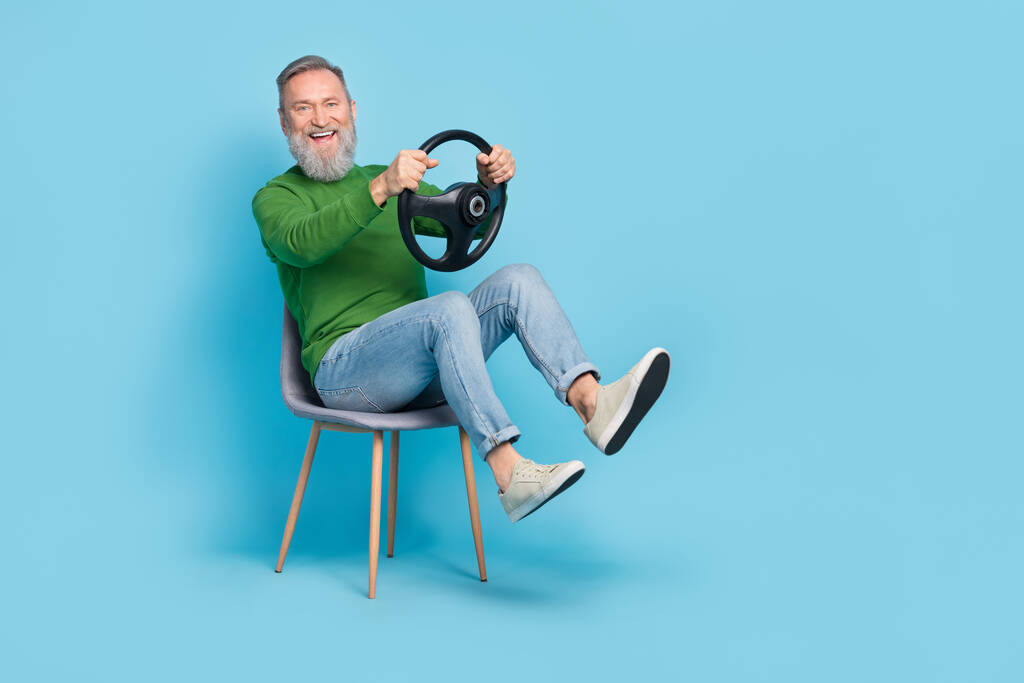 Photo of aged man hold steering wheel play race road route journey wear jeans jumper isolated blue color background. - Photo, Image