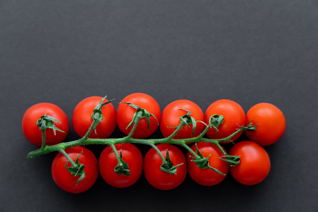 Vista superior de tomates cherry en rama sobre fondo negro  - Foto, Imagen