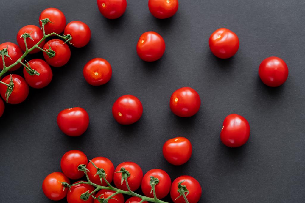 Horní pohled na celá cherry rajčata na černém pozadí  - Fotografie, Obrázek