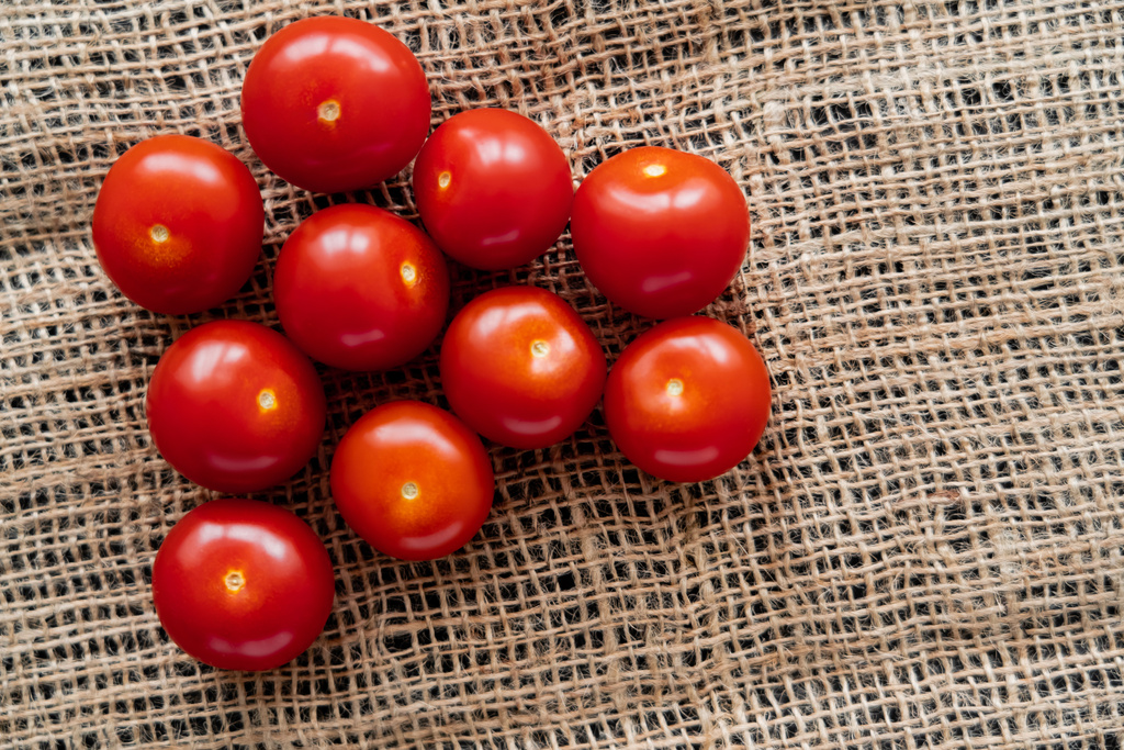 Top view of fresh cherry tomatoes on sackcloth  - Photo, Image
