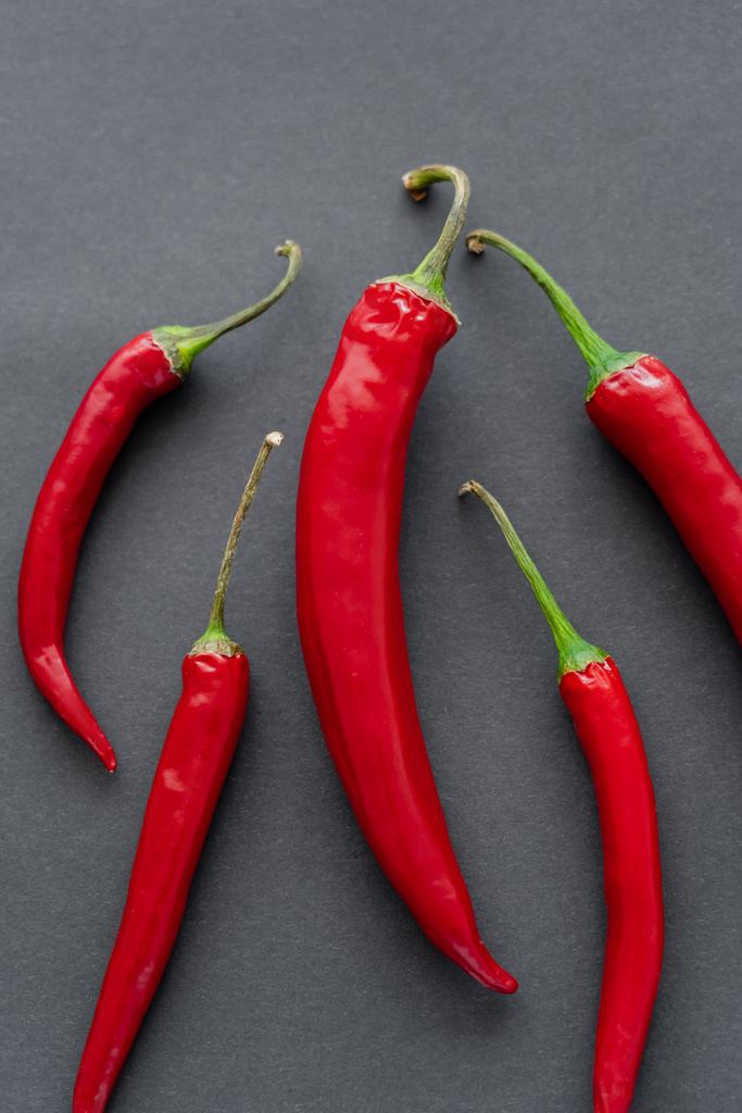 Bovenaanzicht van chili pepers op zwarte achtergrond  - Foto, afbeelding