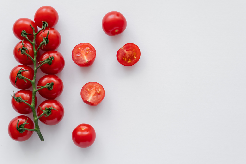 Bütünün üst görüntüsü ve beyaz arkaplanda kiraz domatesleri kesimi  - Fotoğraf, Görsel