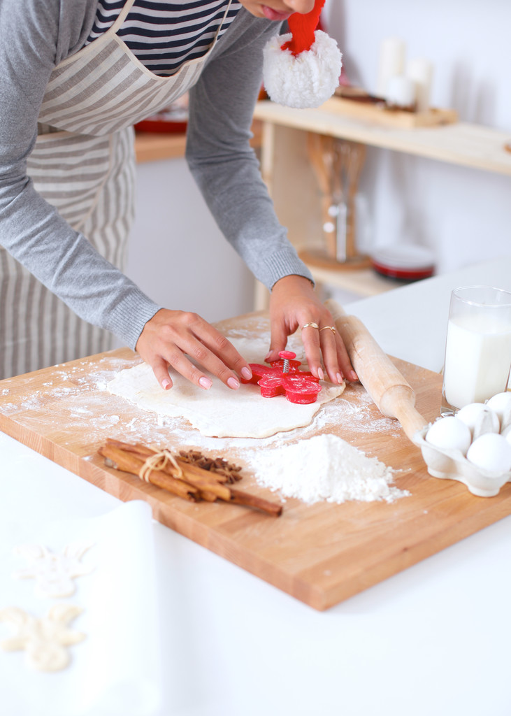 Женщина делает рождественское печенье на кухне - Фото, изображение