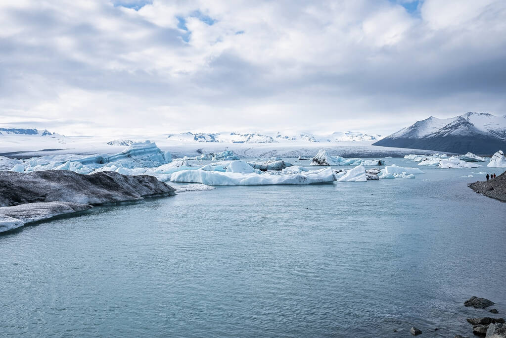 Belle vue sur les icebergs flottant dans la lagune des glaciers. Vue panoramique des formations glaciaires contre un ciel nuageux. Paysage idyllique de la lagune du glacier Jokulsarlon par temps extrême. - Photo, image