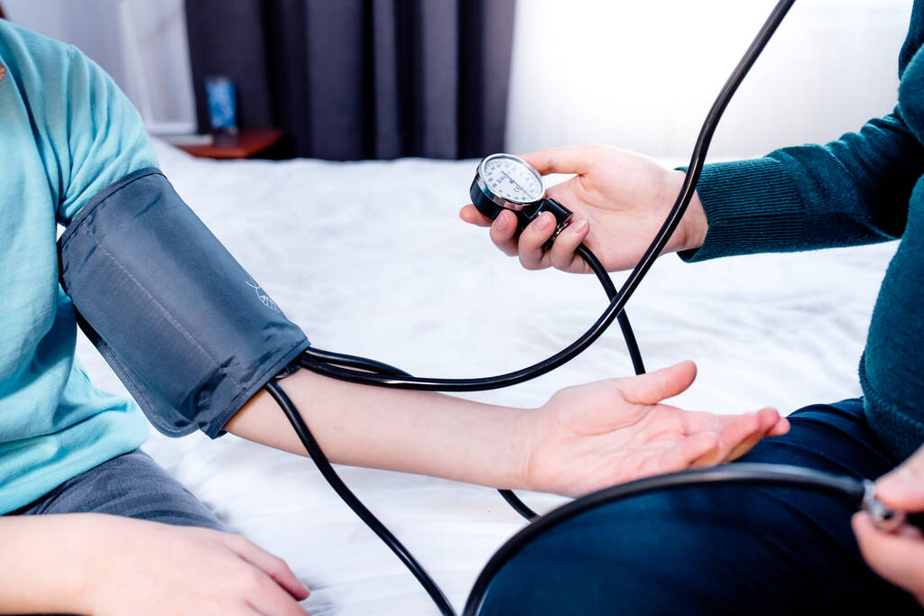 Žena měří krevní tlak dítěte pomocí tlakového pouzdra a stetoskopu. doma. zavřít - Fotografie, Obrázek