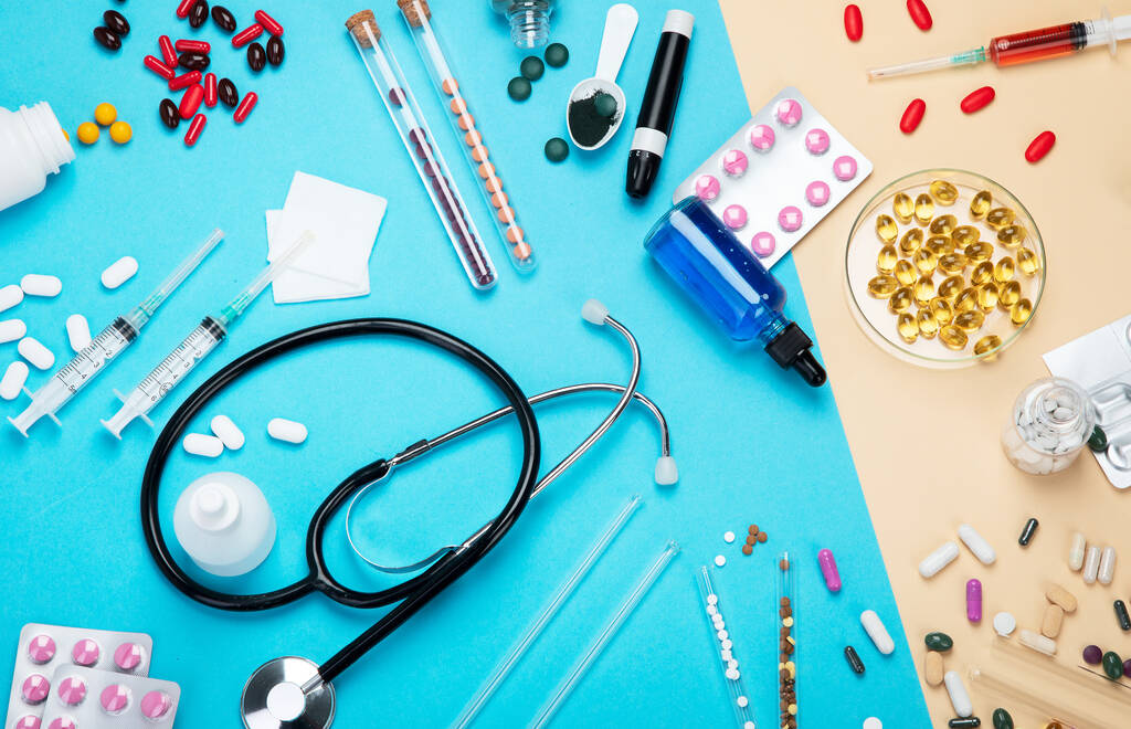 Diverse medische apparatuur, ampullen, pipet, medicijnen, tabletten, capsules, spray op blauwe achtergrond. Bovenaanzicht. - Foto, afbeelding