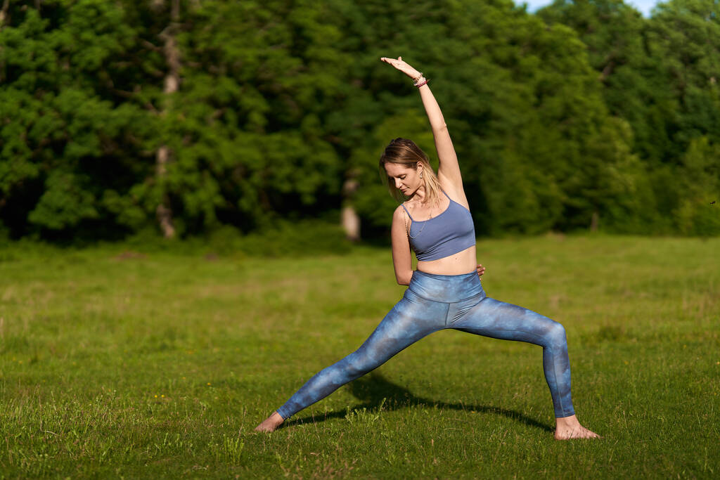 Nuori nainen harjoittelee joogaa ja meditaatiota satavuotiaiden tammien metsässä - Valokuva, kuva