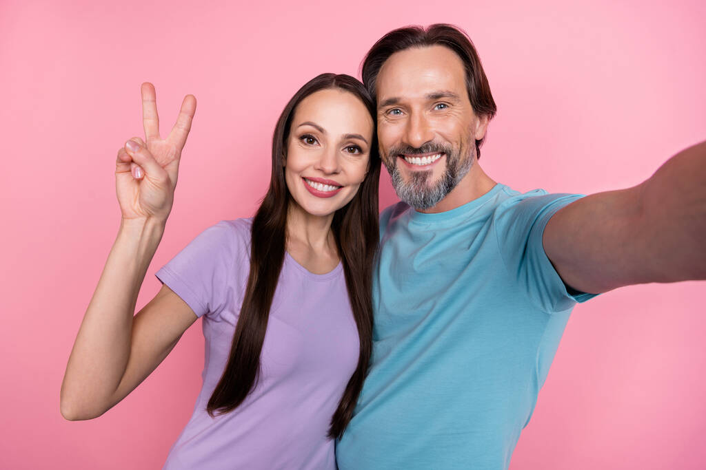 Kuva kaksi kumppania tehdä selfie käsi sormet osoittaa v-merkki eristetty vaaleanpunainen väri tausta. - Valokuva, kuva