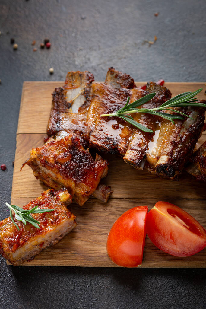 Sliced roasted ribs bbq and tomatoes on wooden boards food  - Photo, Image