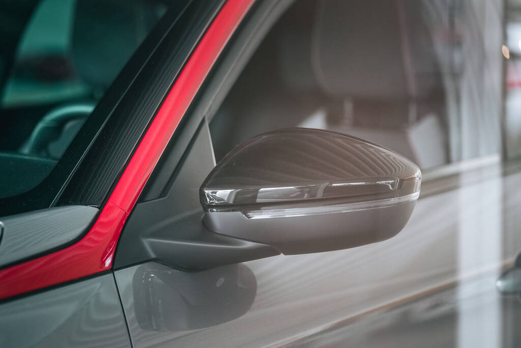 Un primer plano de un espejo retrovisor de un coche moderno gris y rojo - Foto, Imagen