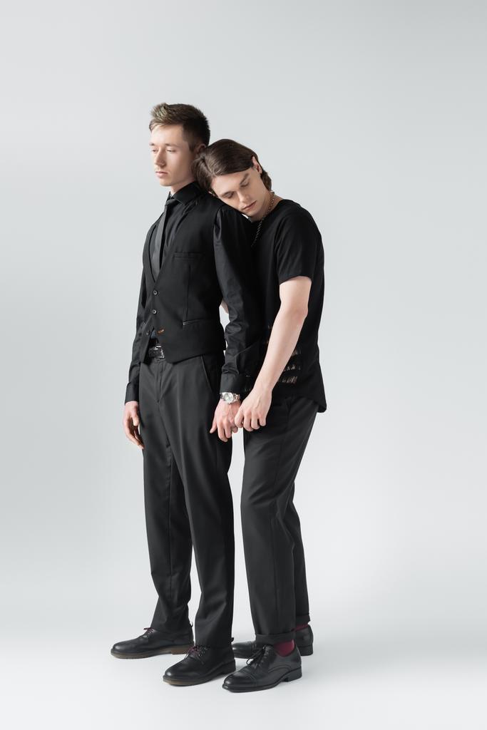 voll Länge der junge gay paar halten Hände auf grau Hintergrund  - Foto, Bild