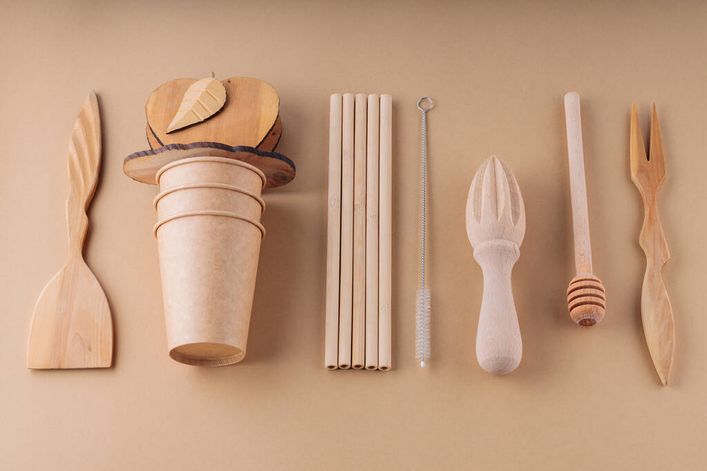 Fa evőeszközök és papír eldobható csésze bézs alapon. Fából készült edények, bambusz szívószálak és tisztító kefe. Fenntartható vagy környezetbarát életmód. Műanyagmentes koncepció - Fotó, kép