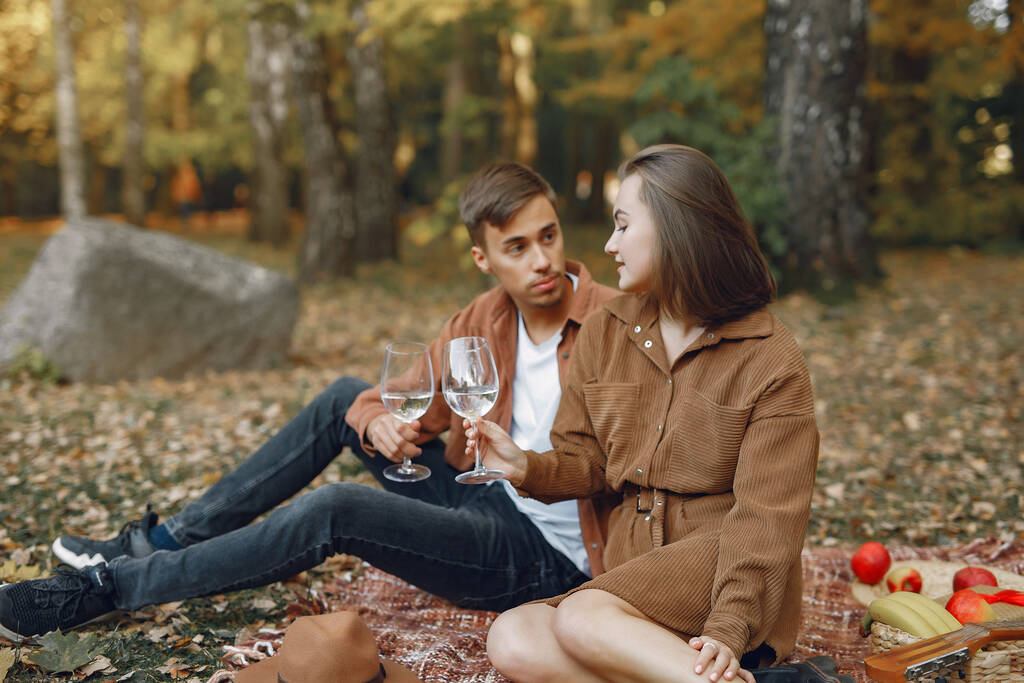 Ένα ζευγάρι σε ένα πάρκο. Ένας τύπος με καφέ πουκάμισο. Χρυσό φθινόπωρο. - Φωτογραφία, εικόνα
