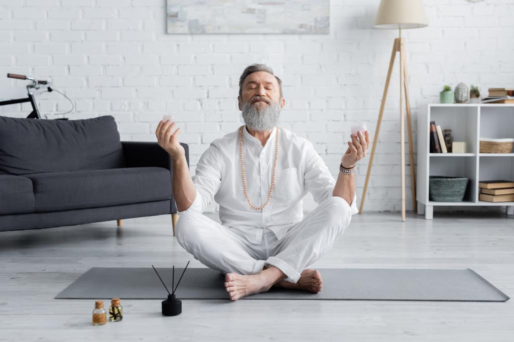 бородатий майстер йоги, роздумуючи в легкій позі біля паличок аромату та ароматизованих олій
 - Фото, зображення