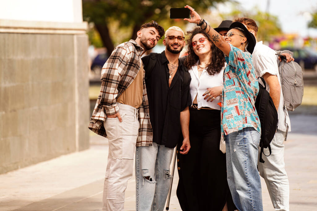 Gruppe junger modischer Freunde, die beim Stadtspaziergang ein Selfie machen, lächeln und Spaß haben. Foto im Freien. Der Lebensstil echter Menschen. Glückliche Studenten.               - Foto, Bild