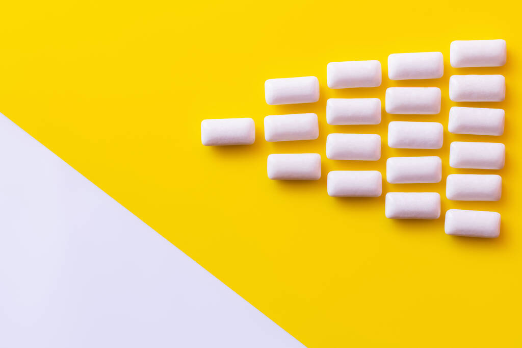 Flat lay with chewing gums on yellow and white surface  - Photo, Image