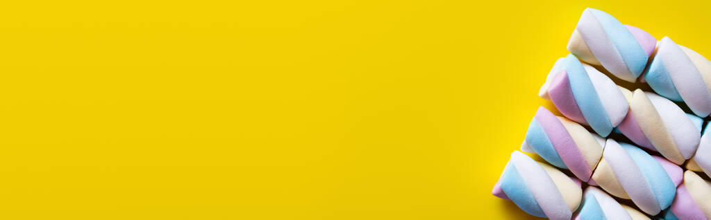 Acostado plano con sabrosos malvaviscos en la superficie amarilla, bandera   - Foto, imagen