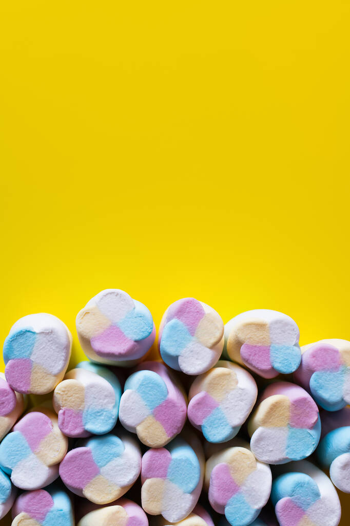Horní pohled na načechrané marshmallows na žlutém povrchu  - Fotografie, Obrázek