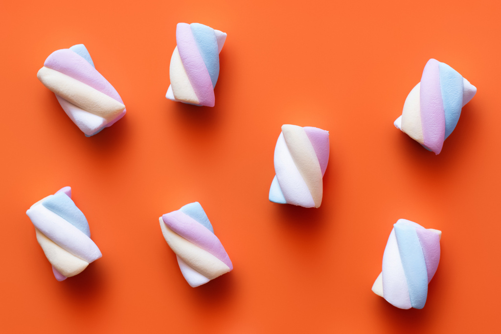 Κάτοψη αφράτου marshmallows σε πορτοκαλί φόντο  - Φωτογραφία, εικόνα